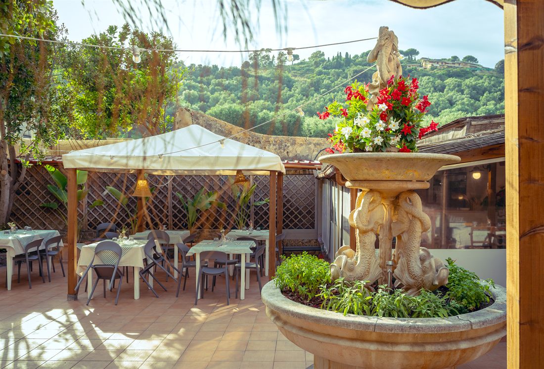 Patio esterno con fontana e tavoli